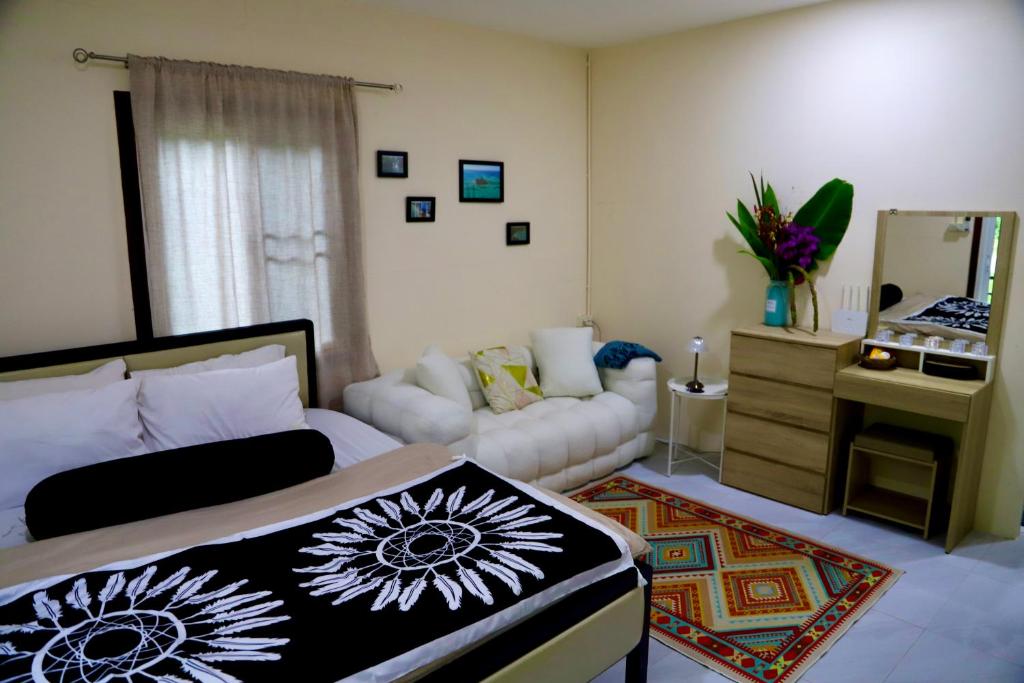 a bedroom with a bed and a living room at Tiny Boutique House Koh Kood in Ban Lak Uan