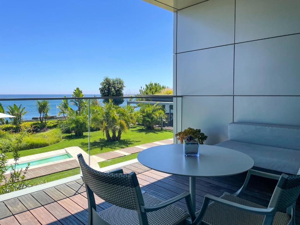 a table and chairs on a patio with a view of the ocean at InterContinental Cascais-Estoril by IHG in Estoril
