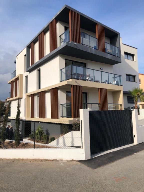 un immeuble d'appartements avec balcon et clôture dans l'établissement Appartement neuf, climatisé et au calme à Fréjus Plage, à Fréjus