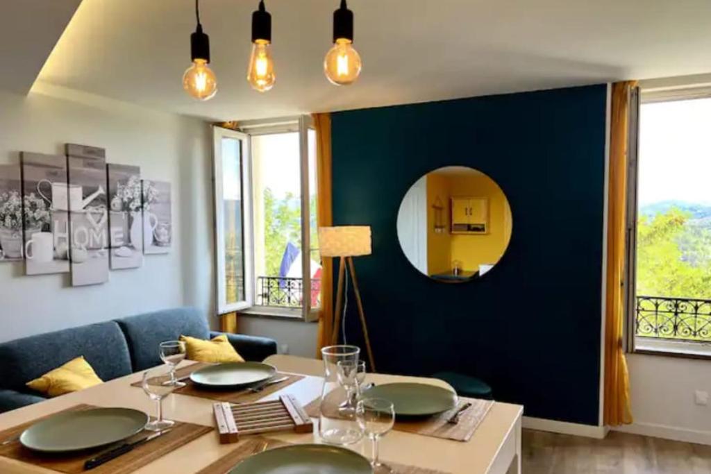 une salle à manger avec une table et un miroir dans l'établissement Scandinavian-style apartment, à Aubenas