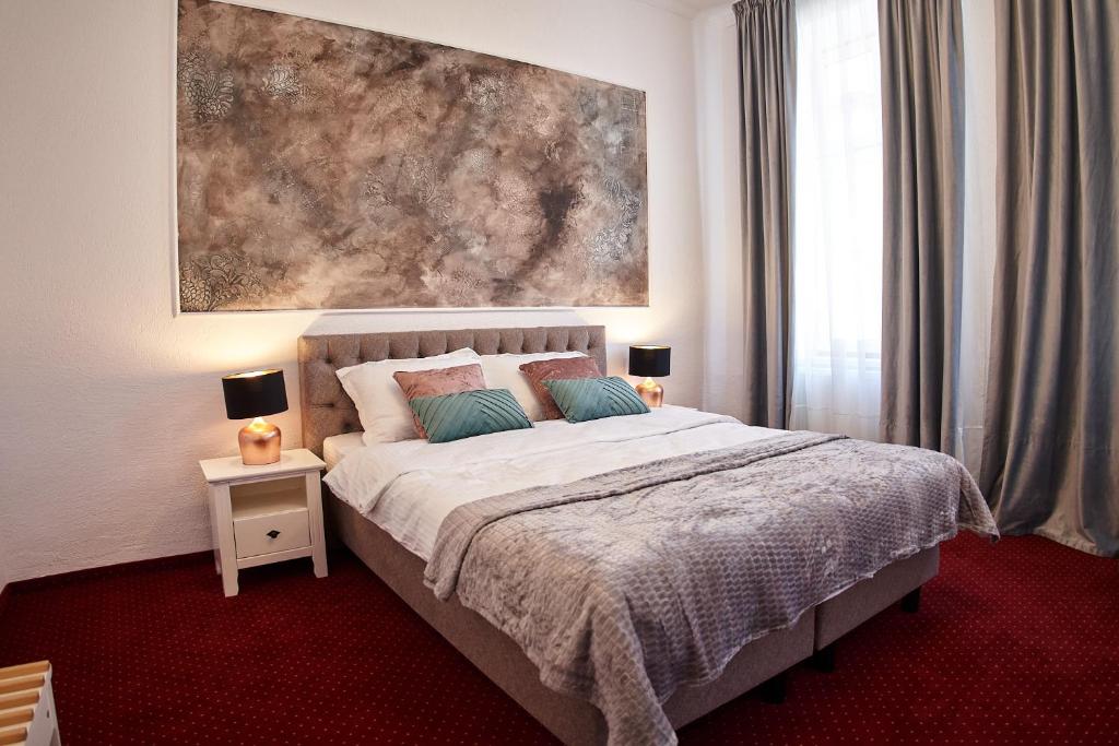 a bedroom with a bed with a painting on the wall at Charma Residence in Sibiu