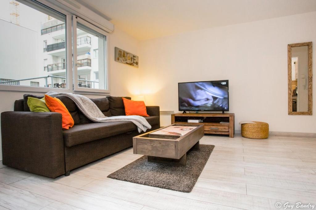 a living room with a couch and a tv at Chic apart with bar in Paris in Saint-Denis