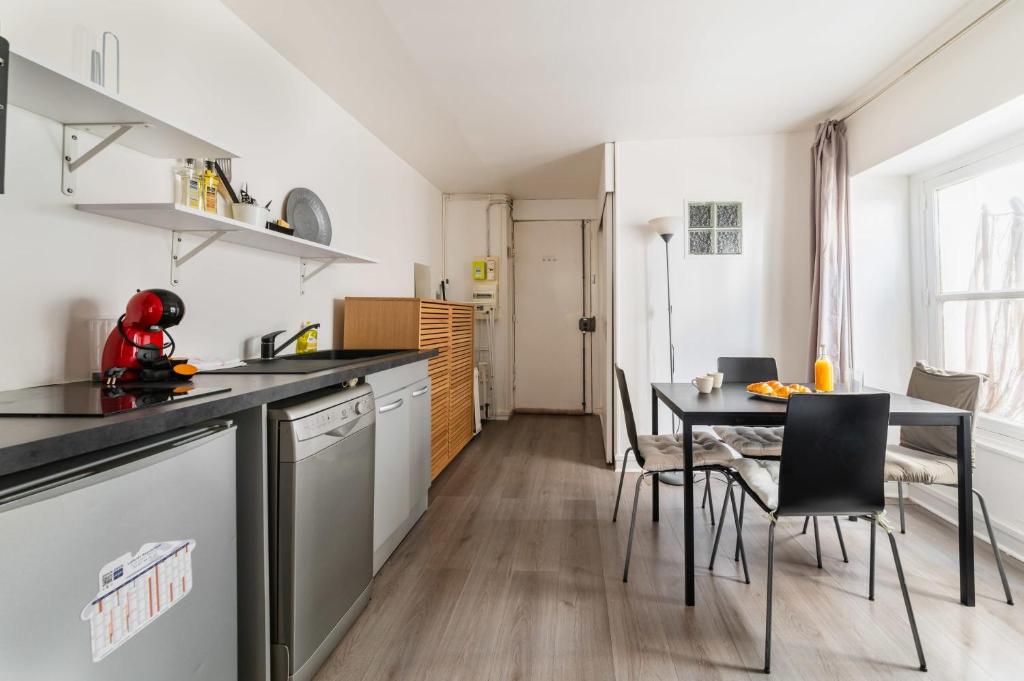 une cuisine et une salle à manger avec une table et des chaises dans l'établissement Grand Studio fonctionnel Republique - Paris 10, à Paris