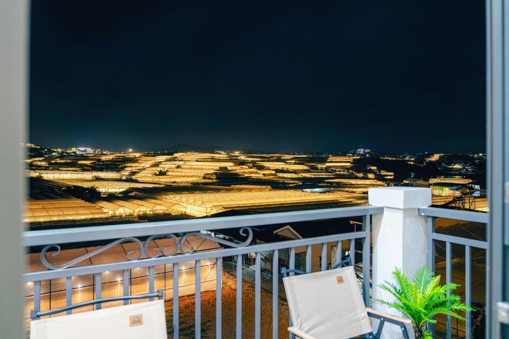 a view of a city from a balcony with two chairs at Teen Hillside Đà Lạt- View Nhà Lồng lãng mạn in Da Lat
