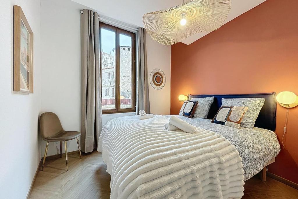 une chambre avec un grand lit et une fenêtre dans l'établissement Le Saint Just - Appartement face à la Cathédrale, à Narbonne