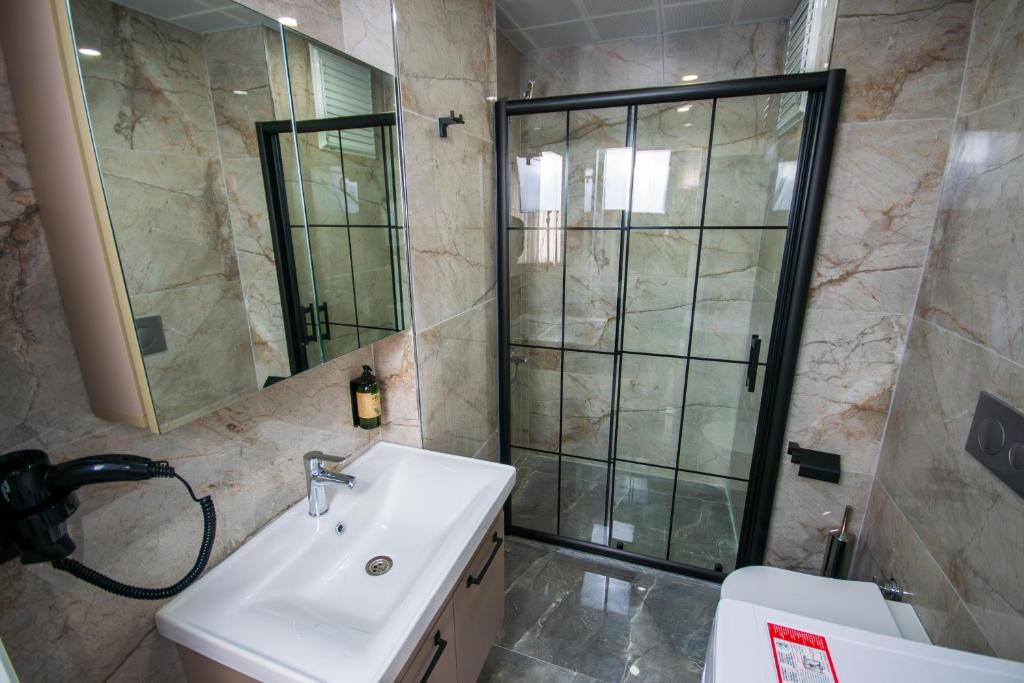 a bathroom with a sink and a shower and a toilet at Luxury Life Suites in Istanbul