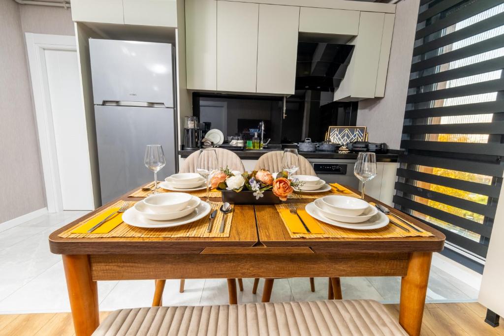 a kitchen with a wooden table with plates and wine glasses at Luxury Life Suites in Istanbul