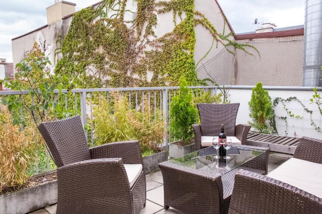 un patio con sillas de mimbre y una mesa de cristal en Vienna-Design-Apartments, en Viena