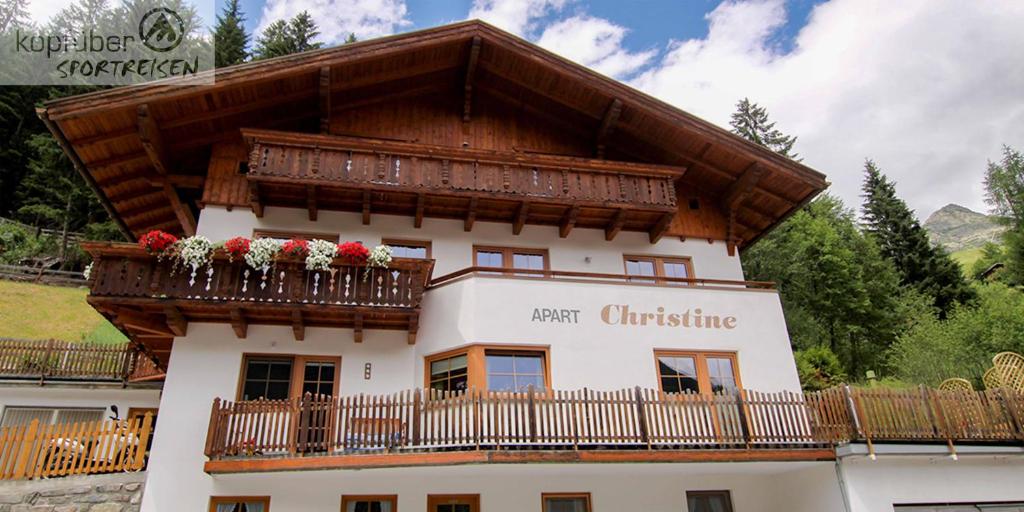 a building with a balcony with flowers on it at Apart Christine in Kappl