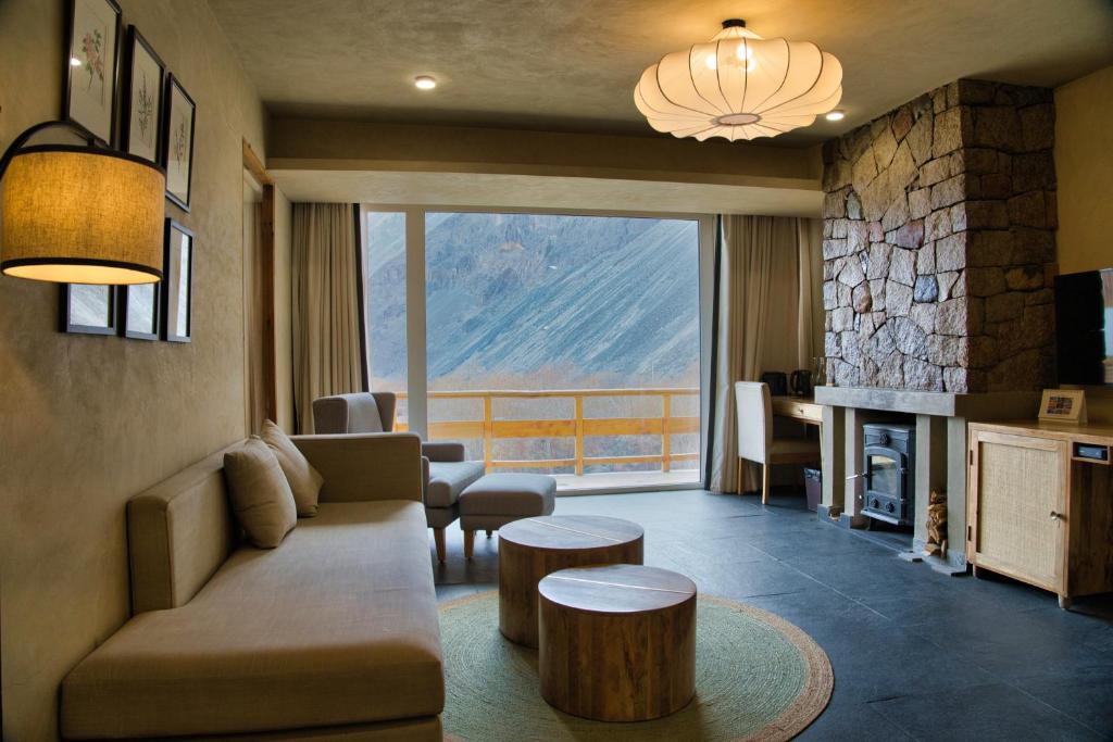 a living room with a couch and a fireplace at Stone Hedge Hotel in Nubra