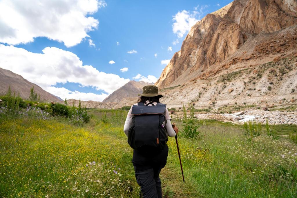 a woman walking down a trail in the mountains at Stone Hedge Hotel in Nubra