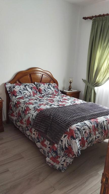 sypialnia z łóżkiem z kołdrą kwiatową w obiekcie Vivienda Vacacional Florentina w mieście Fuencaliente de la Palma