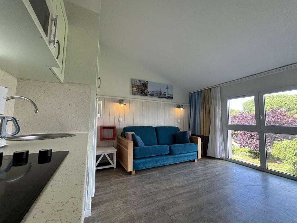 un salon avec un canapé bleu et une fenêtre dans l'établissement Appt 2 pièces ILE DE RE - SAINT MARTIN DE RE - IDR400-062, à Saint-Martin-de-Ré