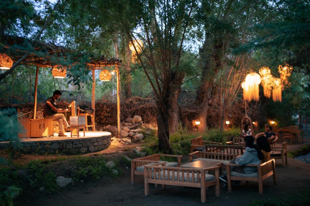 a group of people sitting on benches in a park at Stone Hedge Hotel in Nubra