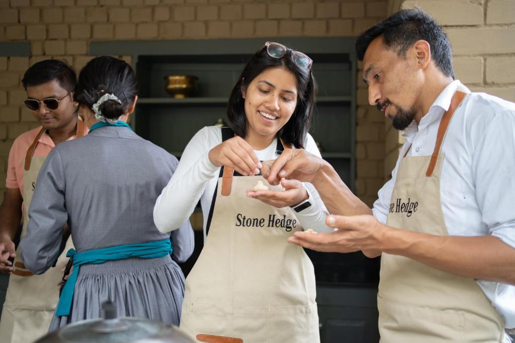 a man and woman in a kitchen preparing food at Stone Hedge Hotel in Nubra