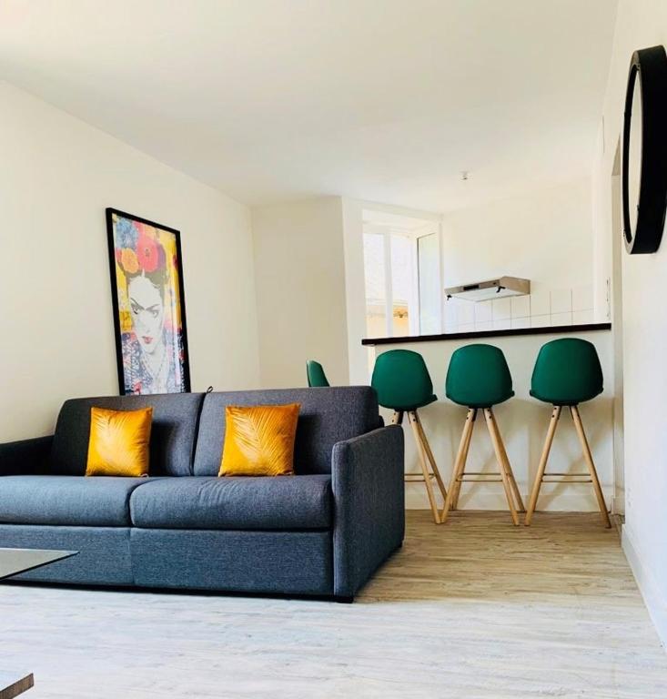 - un salon avec un canapé bleu et des fauteuils verts dans l'établissement Appart - central - Cœur historique, à Sarlat-la-Canéda