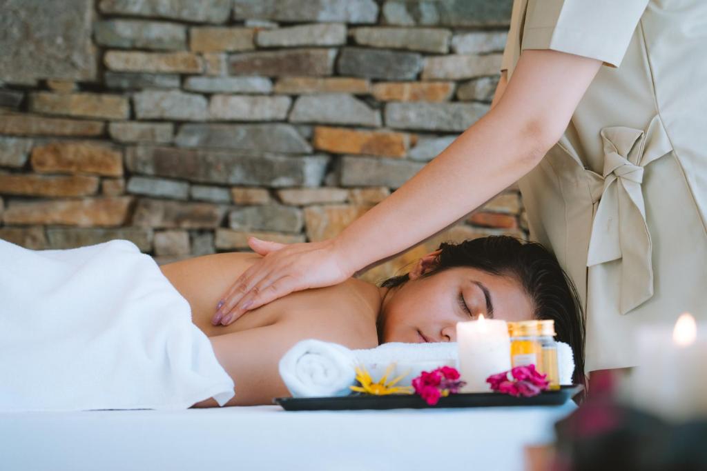 a woman laying in bed getting a massage at Stone Hedge Hotel in Nubra