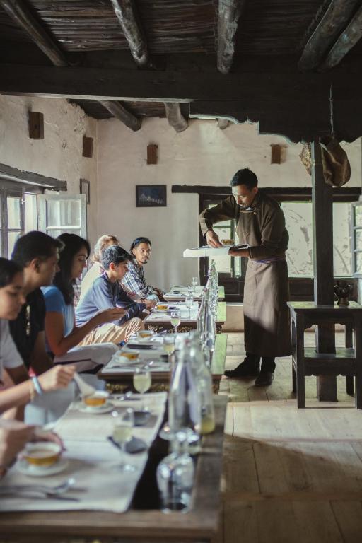 a group of people sitting around a long table at Stone Hedge Hotel in Nubra