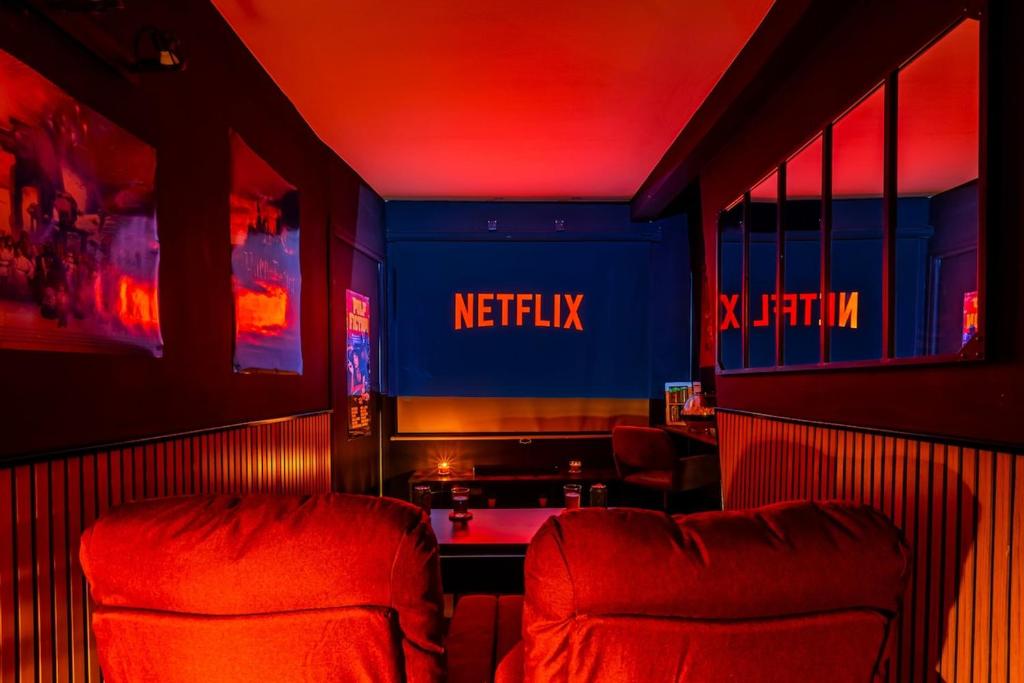 une chaise rouge dans une pièce avec un panneau netflix dans l'établissement Cinéma Love Paris, à Paris
