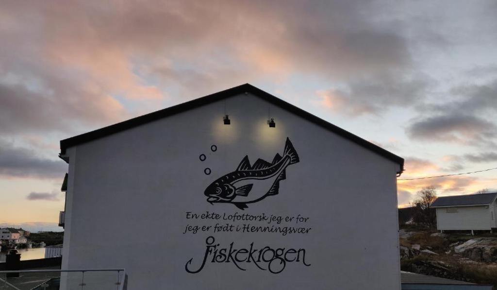 una señal en el costado de un edificio con un pez en él en Fiskekrogen Rorbuer, en Henningsvaer