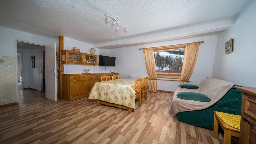 Cette chambre comprend une table, un lit et une cuisine. dans l'établissement Les Etoiles D N60 - 3P8, à Allos