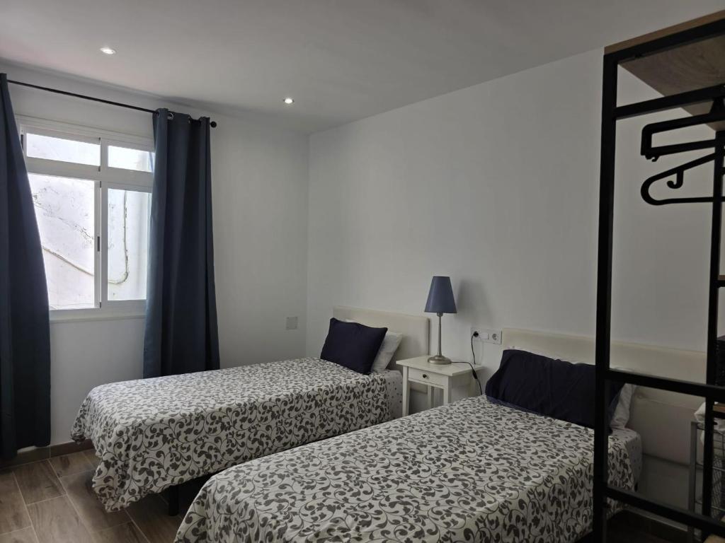a bedroom with two beds and a window at Casa Balcon 2 bedroom by El Sirocco in Puerto de Mogán