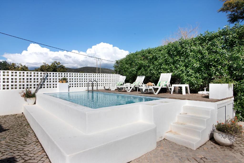 - une piscine blanche avec des chaises dans l'établissement Casa Lavadeira - Vinhas De Nexe, à Faro