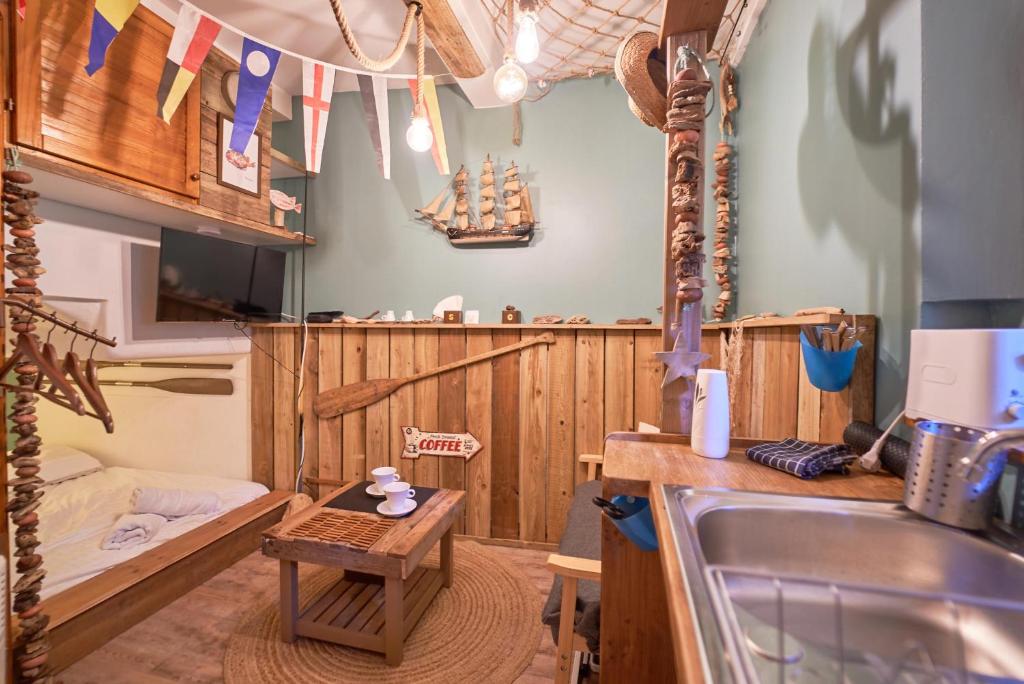 - une cuisine avec évier et un lit dans une chambre dans l'établissement La Cabine du Capitaine - Escale iodé & plage à 100m, à Toulon