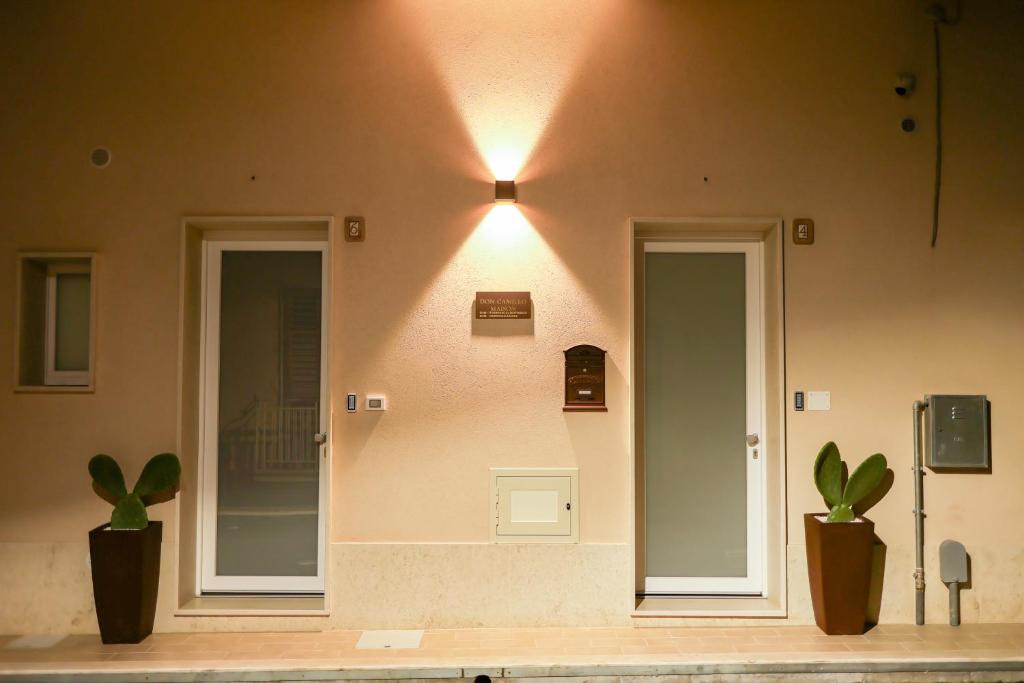 two doors on the side of a building with two plants at Don Camillo Maison in Avola