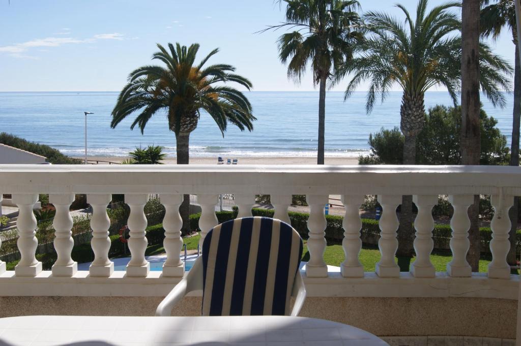 una sedia seduta su un balcone con vista sull'oceano di Apartamentos Casablanca Marineu ad Alcossebre
