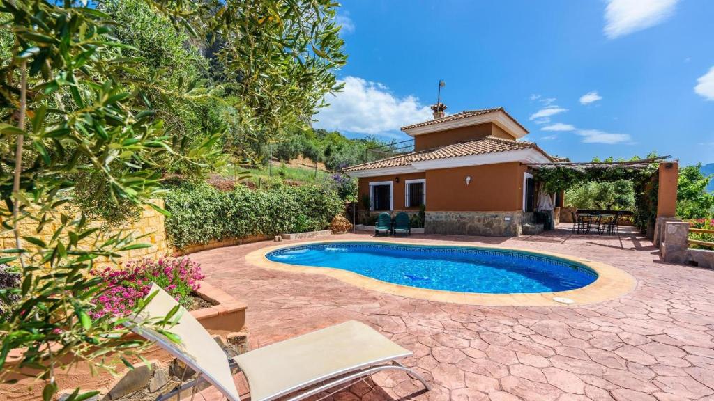 a backyard with a swimming pool and a house at La Roca del Gastor by Ruralidays in El Gastor