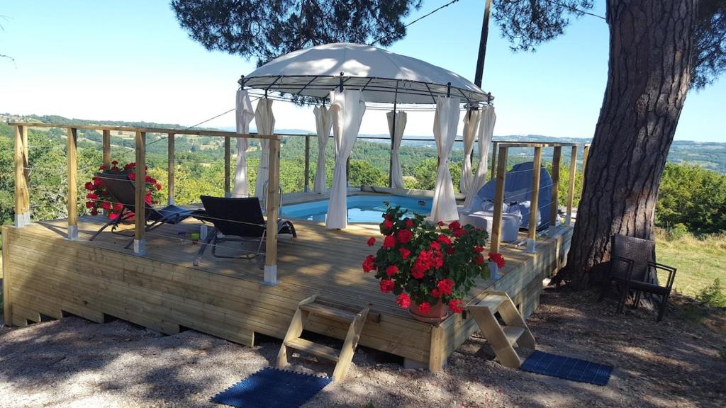 a wooden deck with a gazebo and a pool at Gite Charlotte au Domaine de la Morétie in Cublac