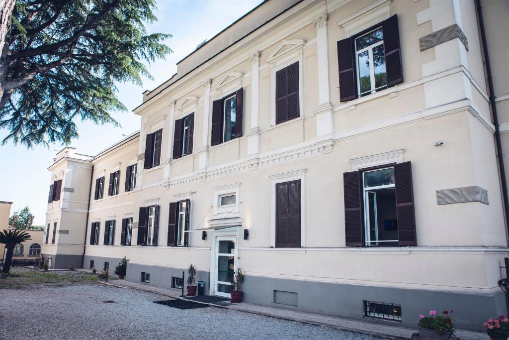 罗马San Luigi - Residenza Gemelli的一座白色的大建筑,设有黑色百叶窗