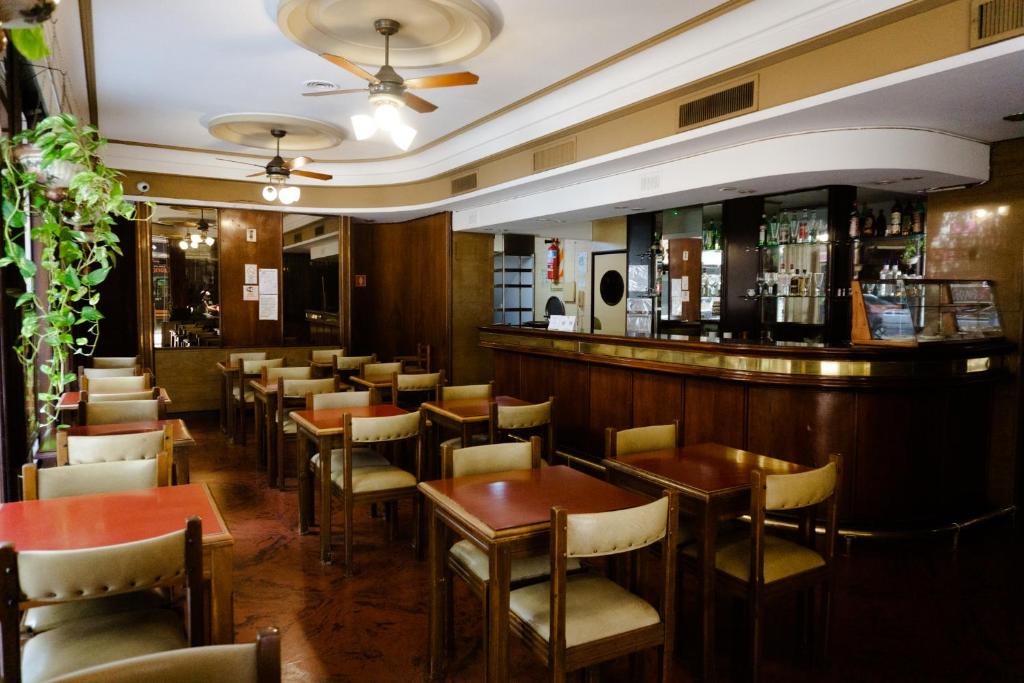 a restaurant with tables and chairs and a bar at Eleven Palace Hotel in Buenos Aires