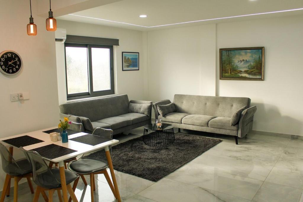 a living room with two couches and a table at Mediterranean Apartments 1 in Paphos City