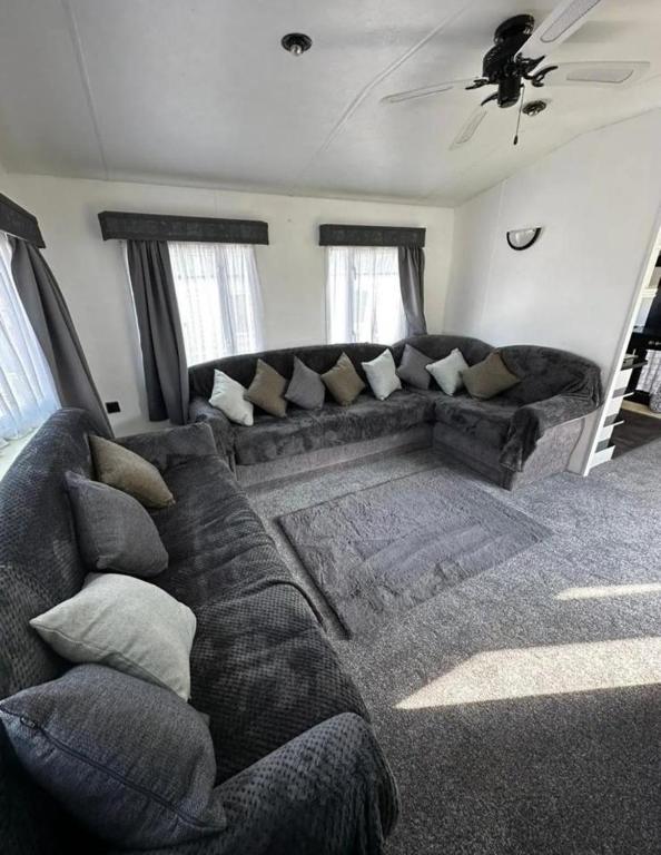 una sala de estar con un sofá grande en una habitación en 2 Bed Mobile Home Sea Views, Centre Field, en Warden