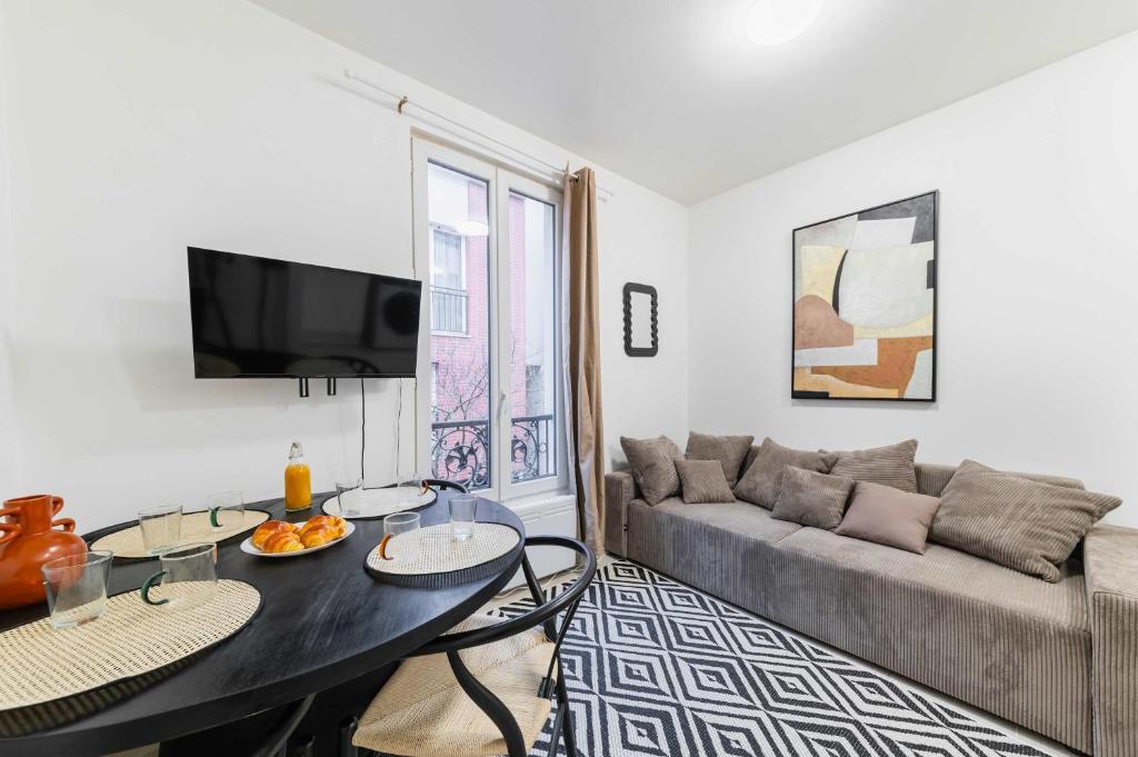 un salon avec une table et un canapé dans l'établissement Appartement cosy hopital bichat - paris 18 - 4P, à Paris