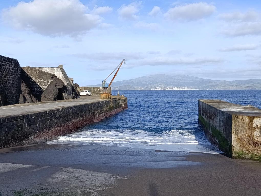 a pier with a crane in the water at Casa do Guardião in Madalena