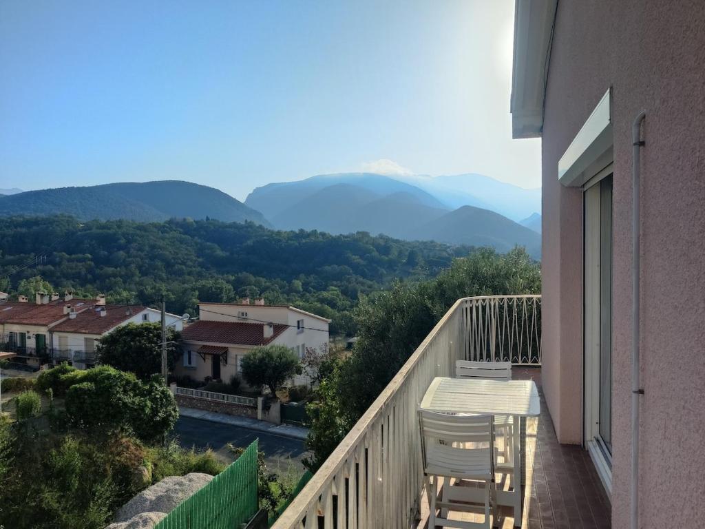 d'un balcon avec deux chaises et une vue sur les montagnes. dans l'établissement Appartement confortable 70m2 au pied du Canigó, à Codalet
