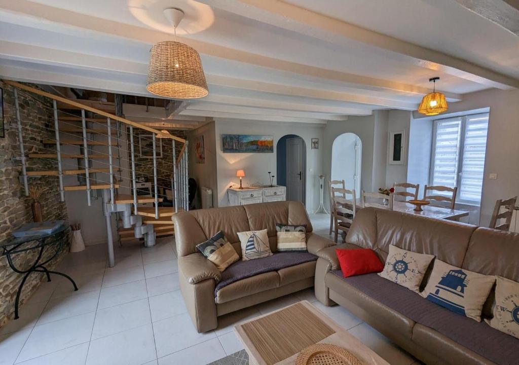 un salon avec deux canapés bruns et une cuisine dans l'établissement GITE PAMPHILIENNE VUE MONT SAINT MICHEL et CAMPAGNE NORMANDE, à Courtils