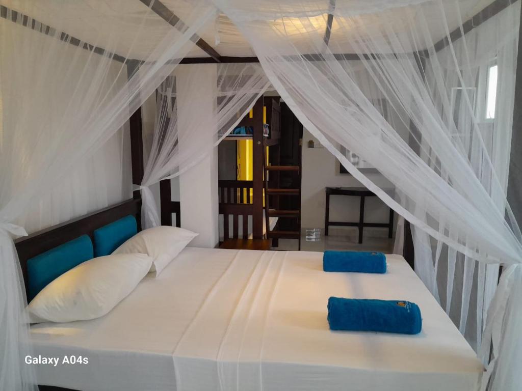 una camera da letto con un letto bianco con cuscini blu di Sea Breeze Guest house a Unawatuna