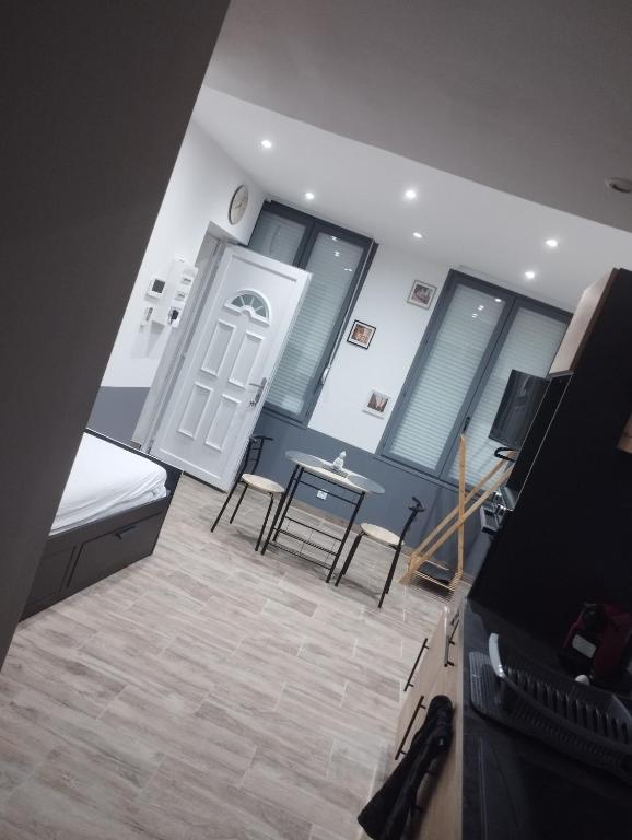 une chambre avec un lit, une table et des chaises dans l'établissement Logement au coeur de saint omer, à Saint-Omer