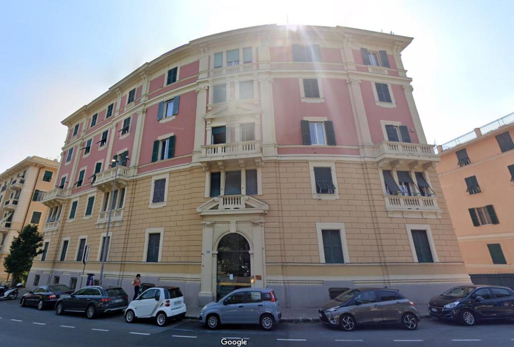a large building with cars parked in front of it at Zovetto Holidays in Genova