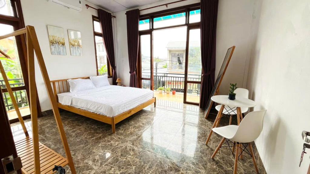 a bedroom with a bed and a balcony at Vang's Homestay - Huế in Ấp Long Hồ Hạ