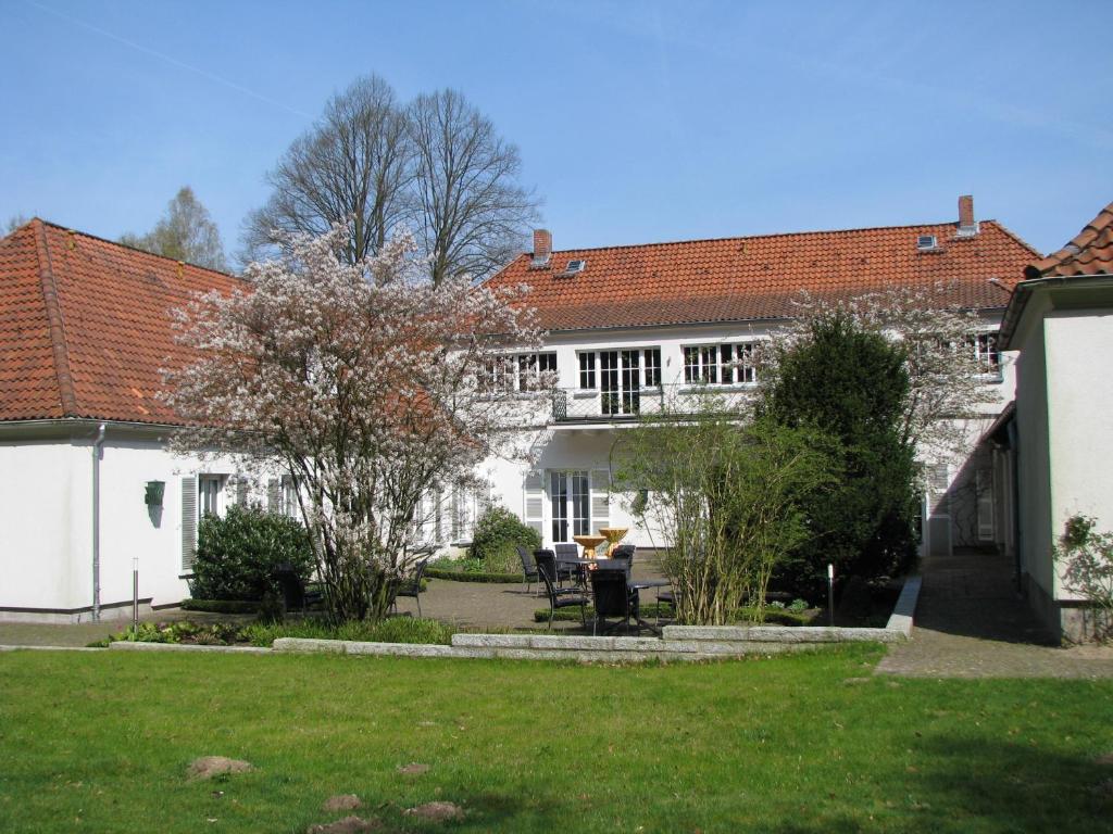 a white house with a table and chairs in a yard at Gästehaus Villa Wolff in Bomlitz