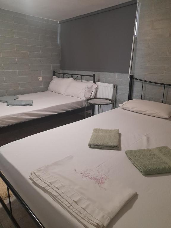 two beds in a room with towels on them at Antonioy Apartment Kalampaka in Kalabaka
