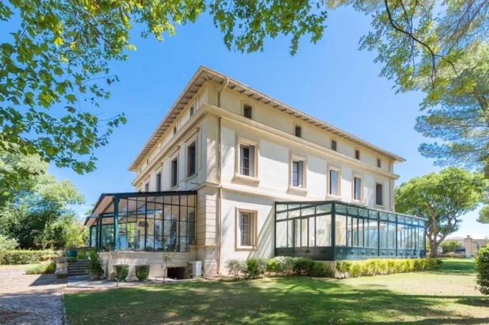 a large white house with glass windows on a yard at Château Sainte Colombe in Saint-Geniès-des-Mourgues