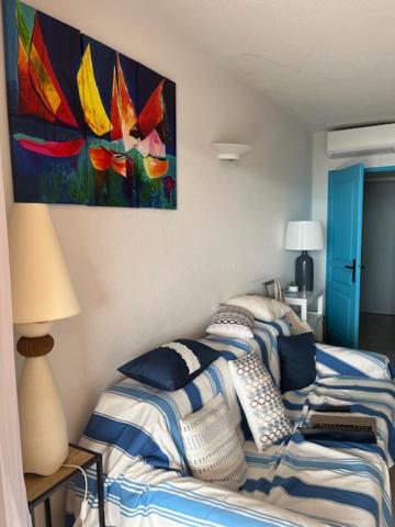 une chambre avec un lit et un tableau au mur dans l'établissement Ajaccio appartement vue mer, à Ajaccio