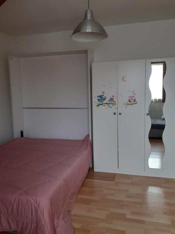 une chambre avec un lit et un mur blanc dans l'établissement Appartement prés du Park de champigny sur Marne, à Champigny-sur-Marne