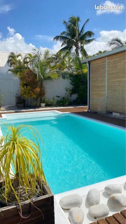 a large blue swimming pool next to a house at Kazanou in Saint-Pierre